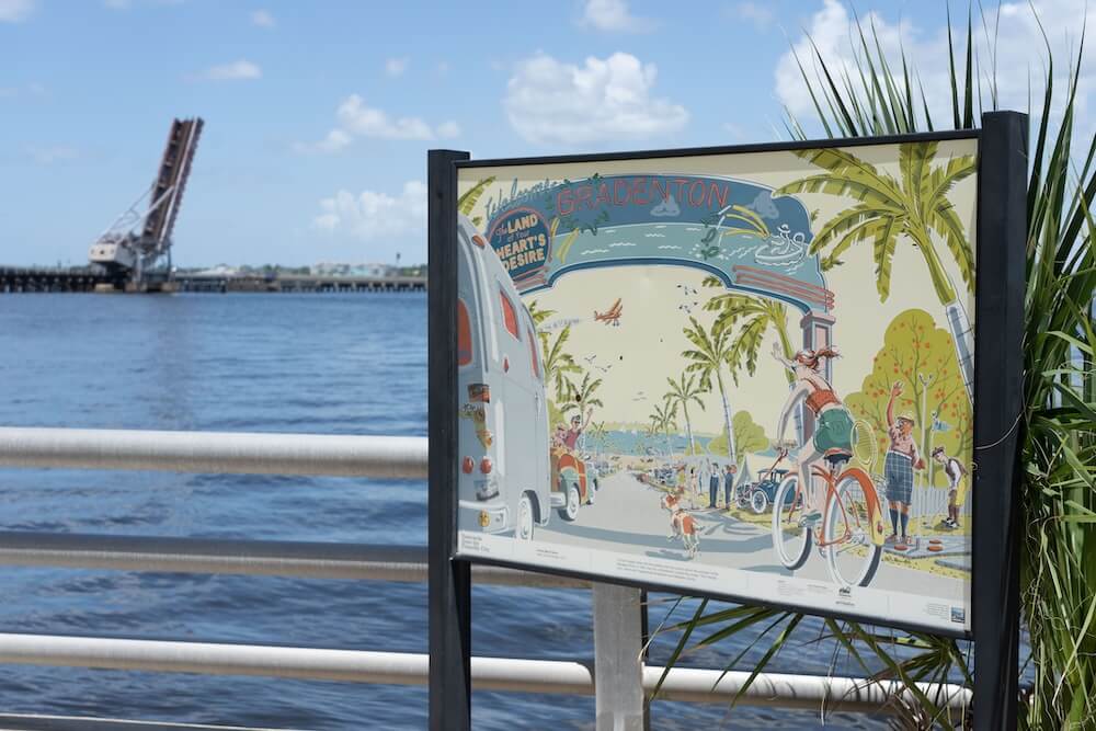 Where to see public art freestanding postcard with a view of the manatee river
