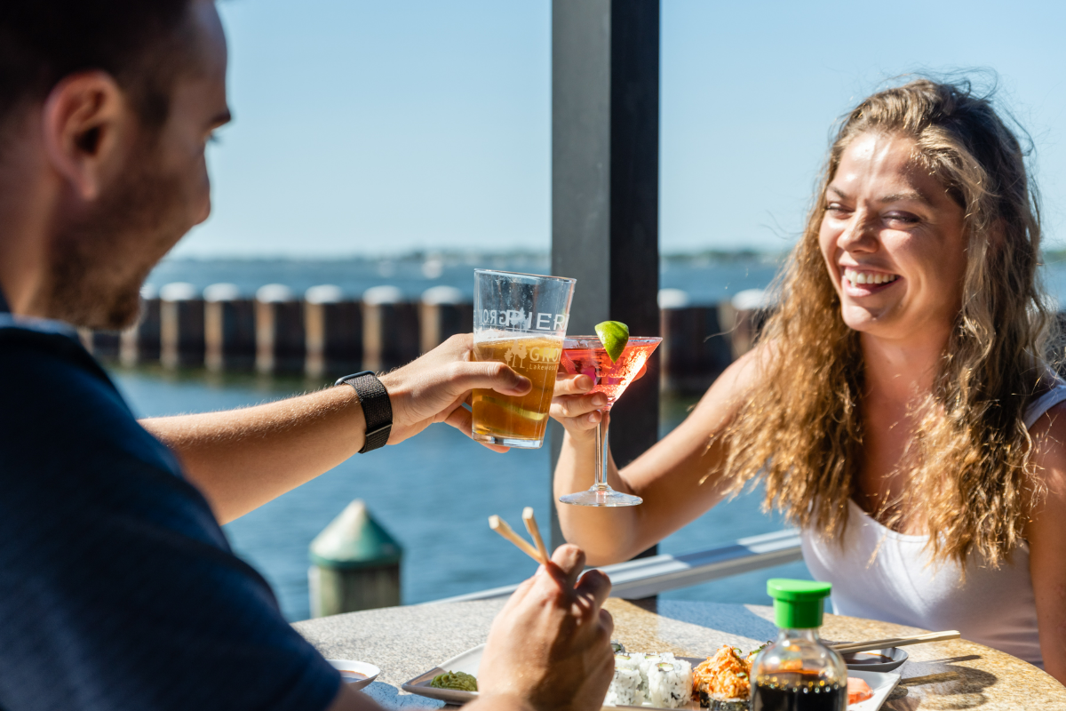 Explore the Gulf Island Ferry Stops a man and woman holding drinks at Pier 22 with a view of the Manatee River