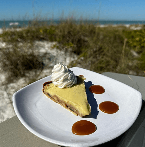 Beachside Bites: Top Toes-in-the-Sand Dining Destinations on Anna Maria Island slice of key lime pie on the beach from Sandbar Restaurant