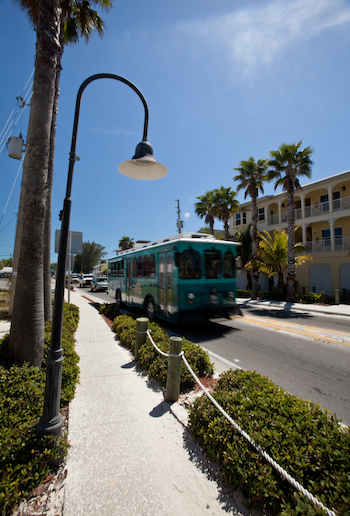 Explore the Gulf Island Ferry Stops blue/green trolley driving down Gulf Drive on Anna maria island